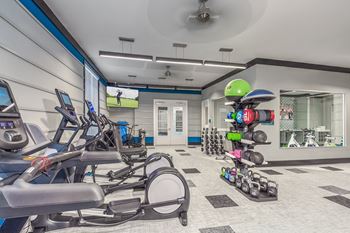 A gym with treadmills, exercise balls, and dumbbells